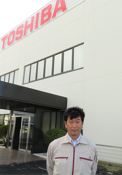 豊前東芝エレクトロニクス 本社 正面玄関に立つ生産技術部 部長 S.Hさん