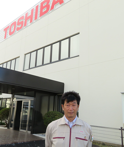 豊前東芝エレクトロニクス 本社 正面玄関に立つ生産技術部 部長 S.Hさん