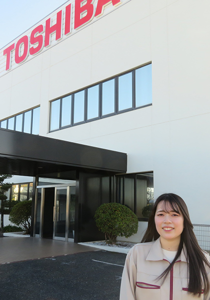 豊前東芝エレクトロニクス 本社 正面玄関に立つ技術部 部品・プロセス技術担当 T.Kさん