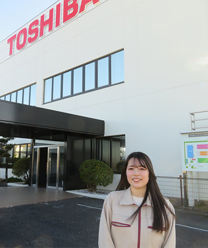 豊前東芝エレクトロニクス 本社 正面玄関に立つ技術部 部品・プロセス技術担当 T.Kさん